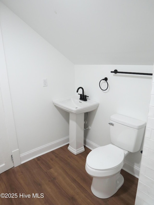 bathroom with baseboards, toilet, and wood finished floors