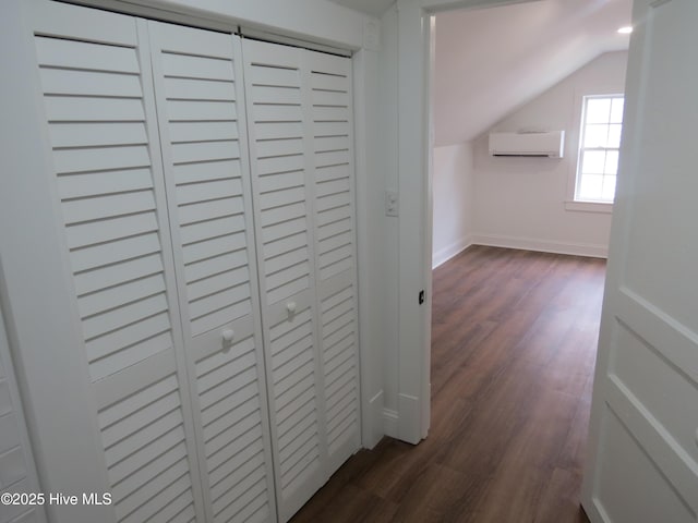 hallway featuring baseboards, vaulted ceiling, dark wood finished floors, and a wall mounted AC