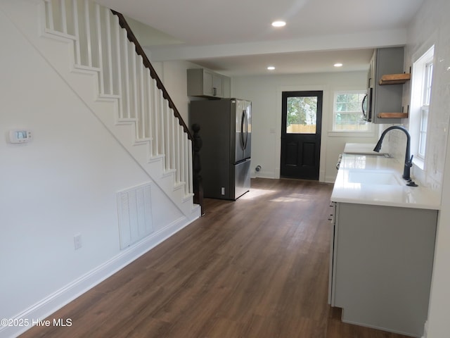 kitchen with a sink, visible vents, appliances with stainless steel finishes, gray cabinets, and open shelves