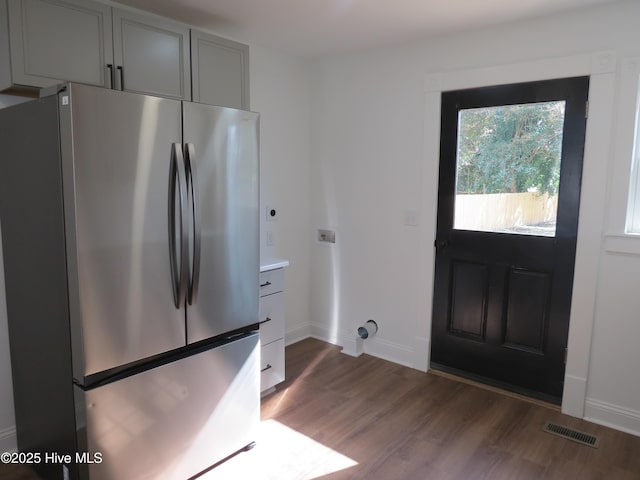 kitchen featuring gray cabinetry, visible vents, baseboards, freestanding refrigerator, and dark wood-style floors