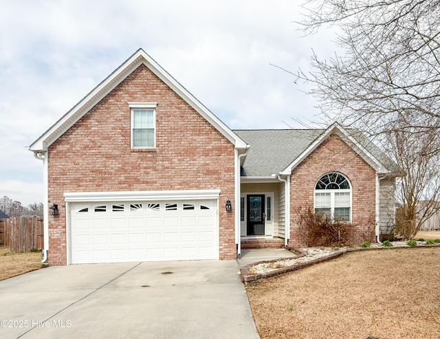 traditional-style house with driveway, an attached garage, fence, and brick siding