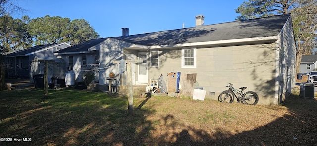 rear view of property featuring a yard, crawl space, and cooling unit