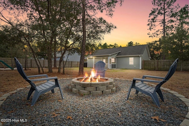 exterior space featuring a fenced backyard and a fire pit