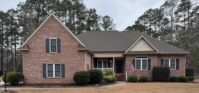 craftsman-style house with a shingled roof and brick siding