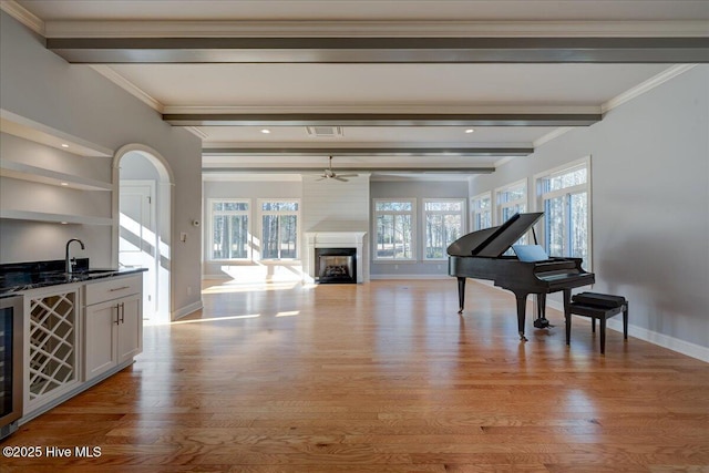 interior space with plenty of natural light, wet bar, and beamed ceiling