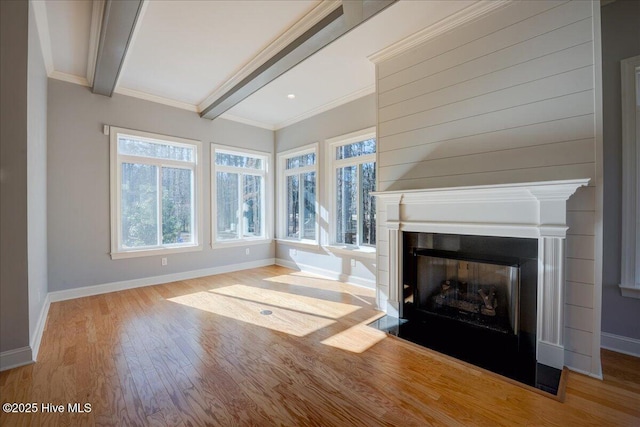 unfurnished living room with beamed ceiling, baseboards, wood finished floors, and a fireplace