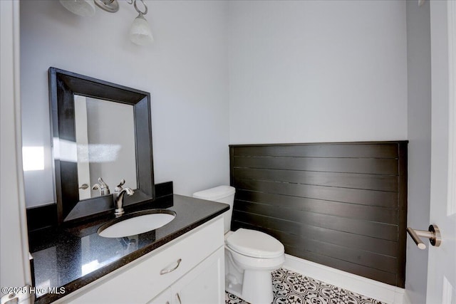 half bath featuring vanity and toilet