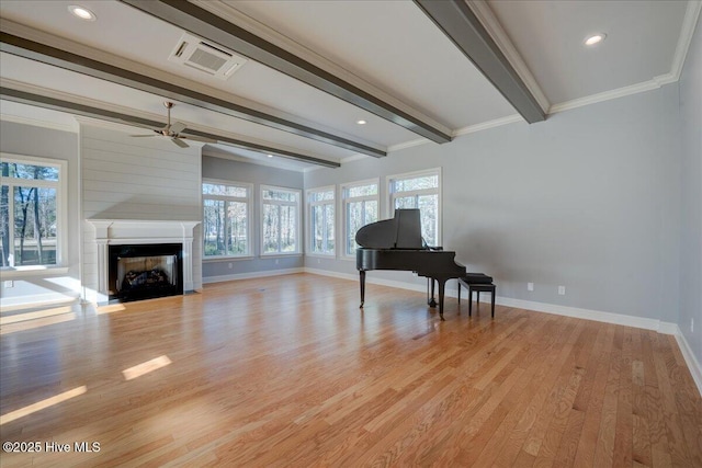 unfurnished room with beam ceiling, a fireplace, visible vents, light wood-type flooring, and baseboards