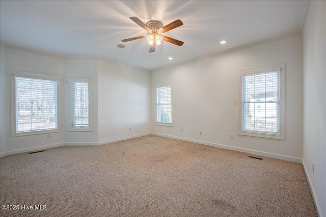 spare room with visible vents, wood finished floors, and ornamental molding