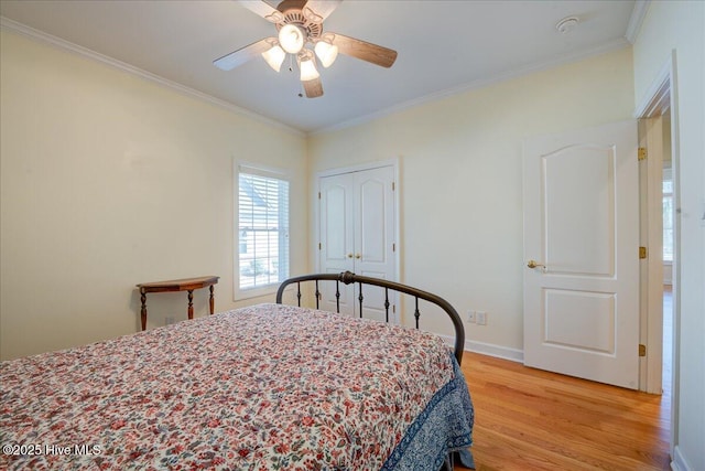 bedroom featuring baseboards, ornamental molding, ceiling fan, and light wood-style floors