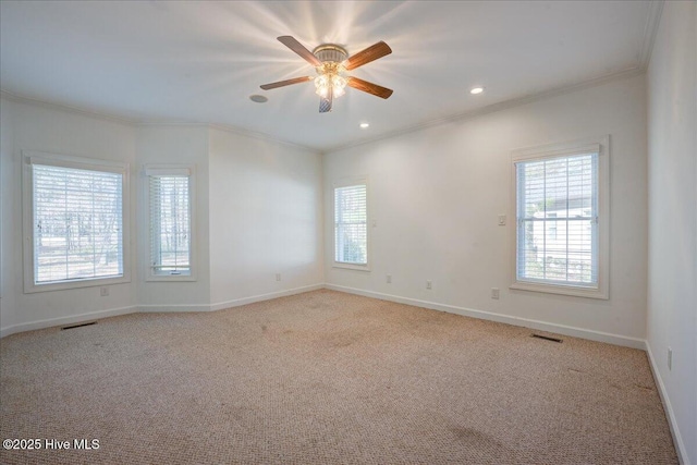 unfurnished room with visible vents, ornamental molding, and a healthy amount of sunlight