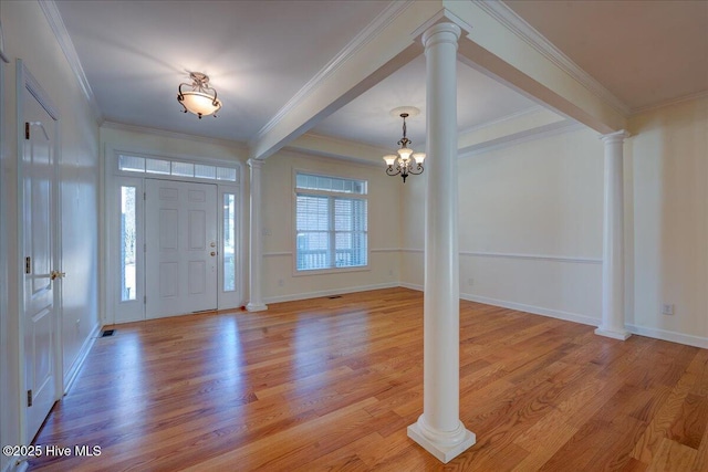 foyer entrance featuring light wood-style flooring, a notable chandelier, baseboards, ornamental molding, and decorative columns