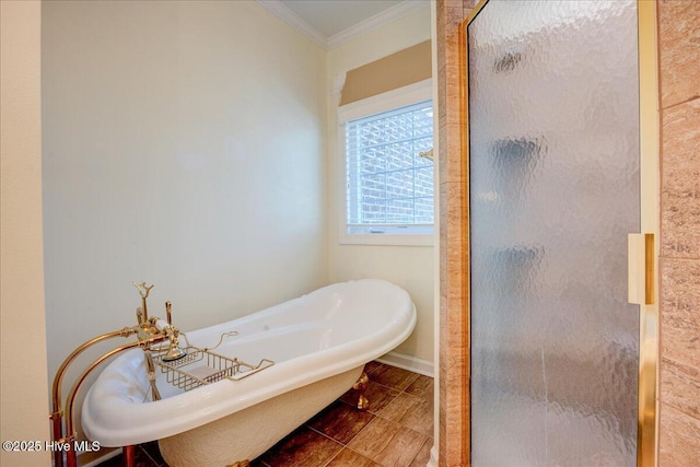 full bath featuring a freestanding tub, a shower stall, ornamental molding, and baseboards