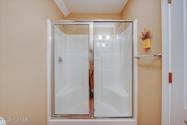 full bath with a stall shower and a textured ceiling
