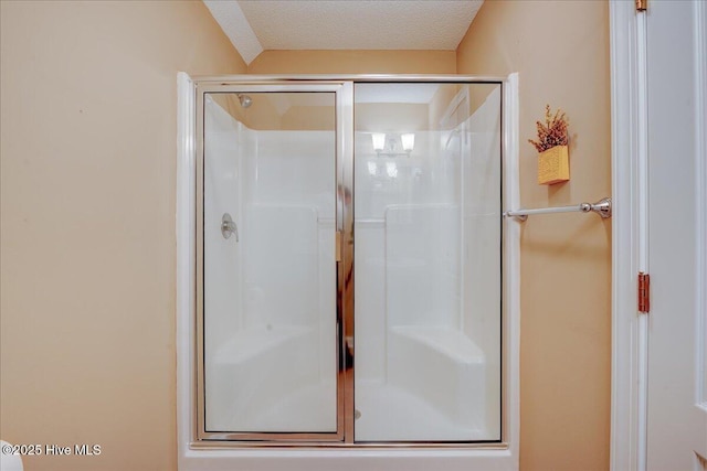 bathroom featuring a textured ceiling and a stall shower