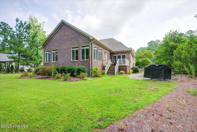 back of house featuring a yard and brick siding