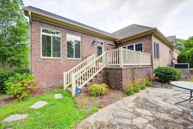 3602 Cranberry Ln, New Bern, NC 28562 - view of front of property with brick siding, a patio area, a shingled roof, stairway, and central AC