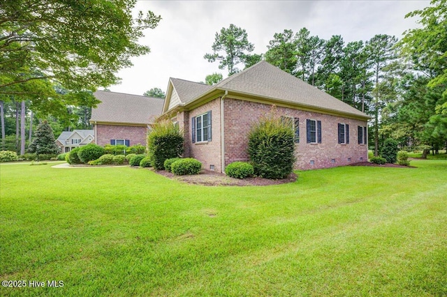 view of side of home featuring a yard, brick siding, crawl space, and roof with shingles