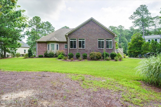 view of front of house with brick siding and a front lawn