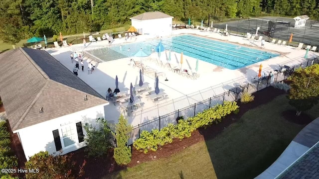 pool featuring fence, a view of trees, and a patio