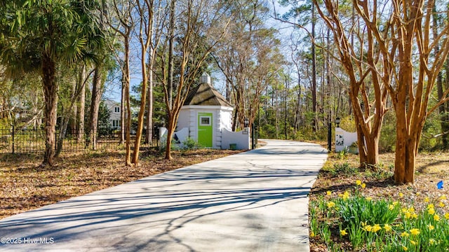 view of side of property featuring driveway and fence