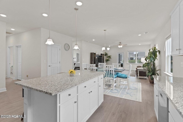 kitchen with decorative light fixtures, recessed lighting, white cabinets, and light wood-style floors