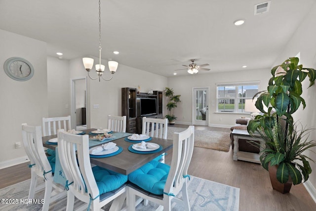 dining area with recessed lighting, ceiling fan with notable chandelier, wood finished floors, visible vents, and baseboards