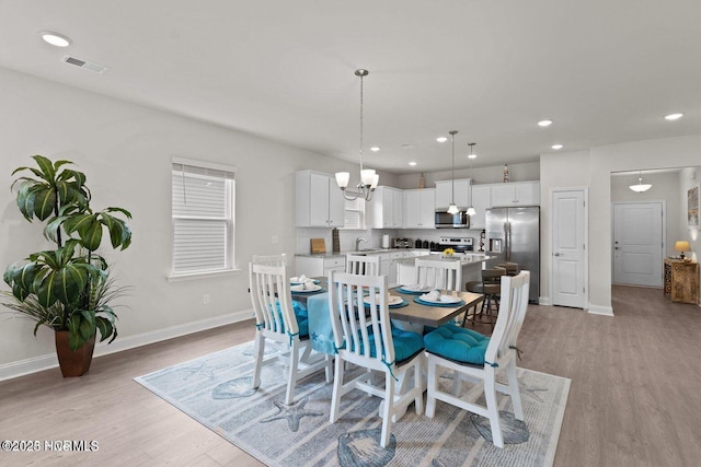 dining room with recessed lighting, visible vents, light wood-style flooring, and baseboards