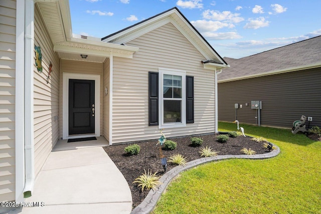 doorway to property featuring a lawn