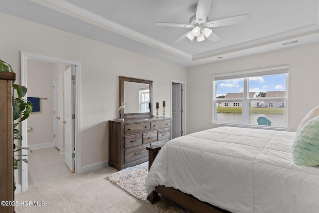 bedroom with a raised ceiling, visible vents, ornamental molding, light carpet, and baseboards