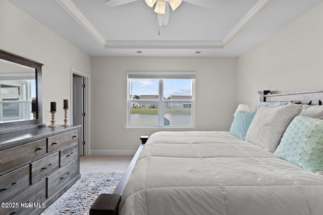 carpeted bedroom featuring baseboards, visible vents, a tray ceiling, and crown molding