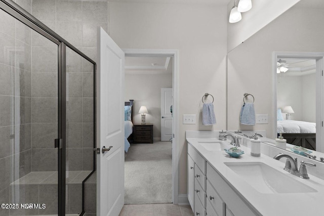 bathroom with double vanity, a sink, a shower stall, and ensuite bathroom