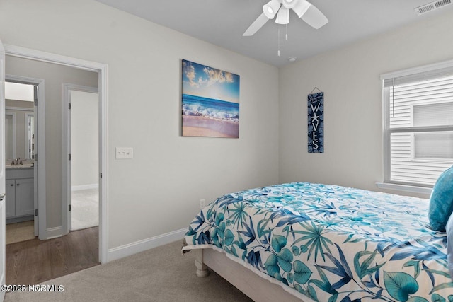 bedroom with visible vents, carpet flooring, a sink, ceiling fan, and baseboards