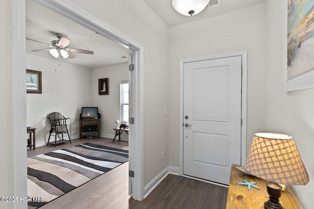 entryway featuring a ceiling fan, dark wood finished floors, and baseboards