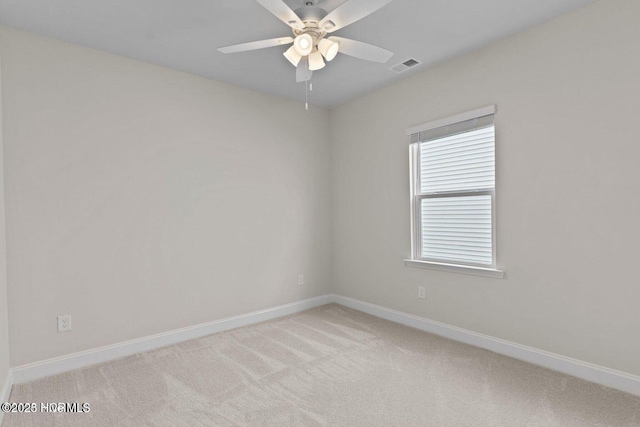 unfurnished room featuring a ceiling fan, light colored carpet, visible vents, and baseboards