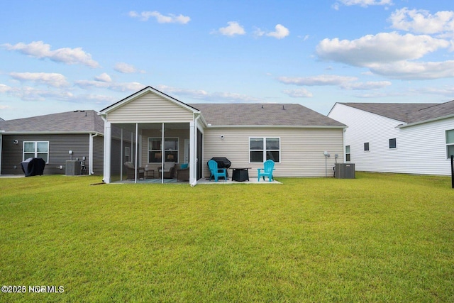 rear view of house with a yard, central AC unit, and a sunroom