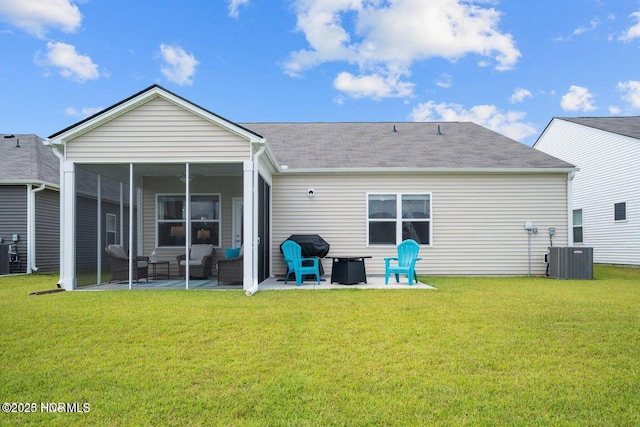 back of property with a sunroom, a lawn, central AC, and a patio