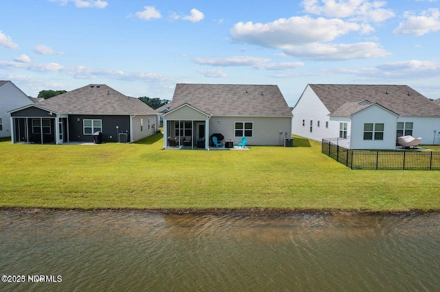 back of house with a yard, a water view, a sunroom, fence, and cooling unit