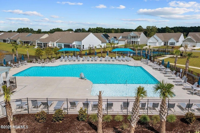 community pool featuring a residential view, a patio area, and fence