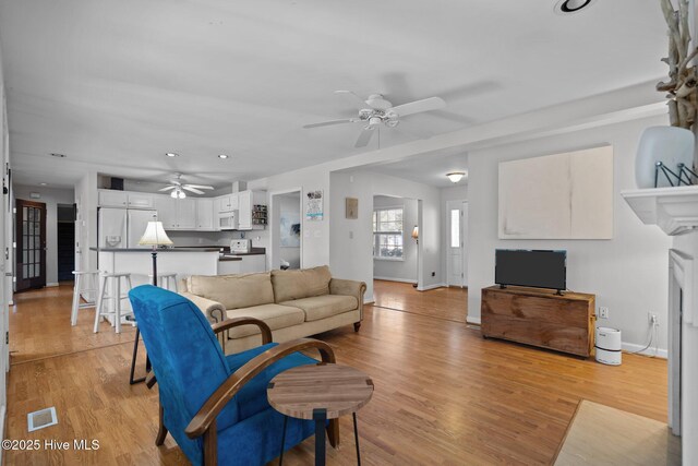 110 SE 7th St, Oak Island, NC 28465 - living area featuring a ceiling fan, baseboards, and light wood-style floors