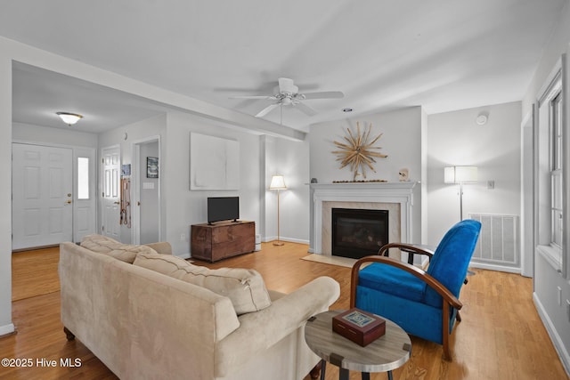110 SE 7th St, Oak Island, NC 28465 - living room with light wood-type flooring, ceiling fan, baseboards, and a fireplace with flush hearth