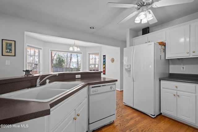 110 SE 7th St, Oak Island, NC 28465 - kitchen with white appliances, a sink, dark countertops, light wood-style flooring, and a ceiling fan