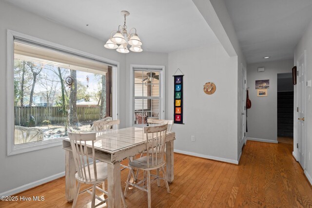 110 SE 7th St, Oak Island, NC 28465 - dining space with a chandelier, baseboards, light wood-style floors, and stairway