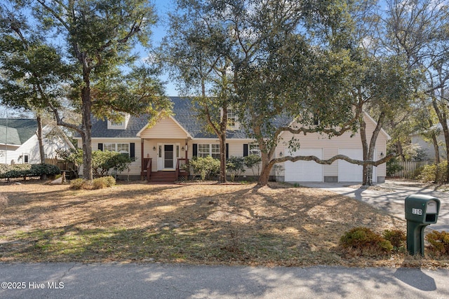 cape cod house featuring a shingled roof, driveway, and an attached garage