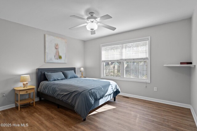 110 SE 7th St, Oak Island, NC 28465 - bedroom with baseboards, wood finished floors, and ceiling fan