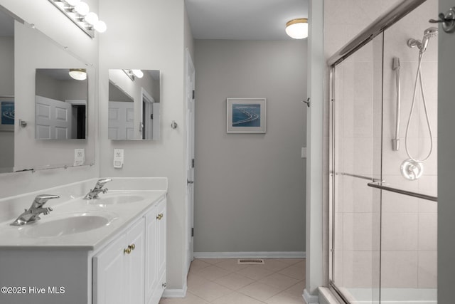 110 SE 7th St, Oak Island, NC 28465 - bathroom featuring a shower stall, tile patterned flooring, double vanity, and baseboards