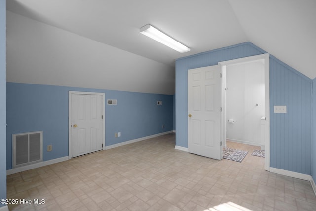 110 SE 7th St, Oak Island, NC 28465 - additional living space featuring brick patterned floors, vaulted ceiling, and baseboards