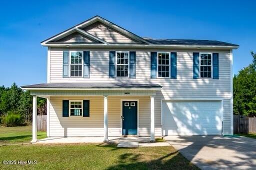 view of front of home featuring driveway, covered porch, an attached garage, and a front yard