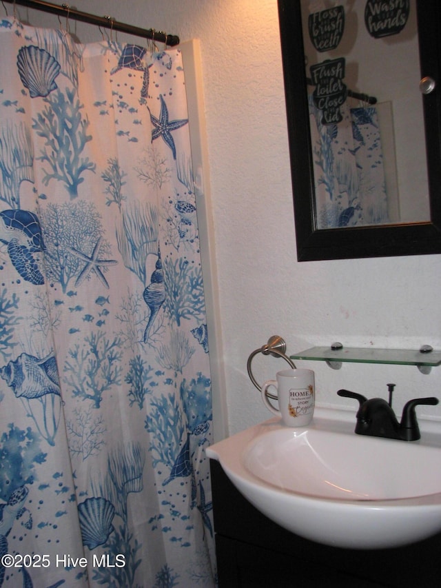 full bathroom featuring curtained shower and vanity