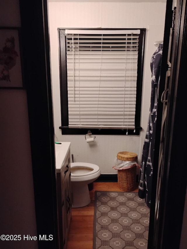 bathroom featuring toilet, wood finished floors, and vanity